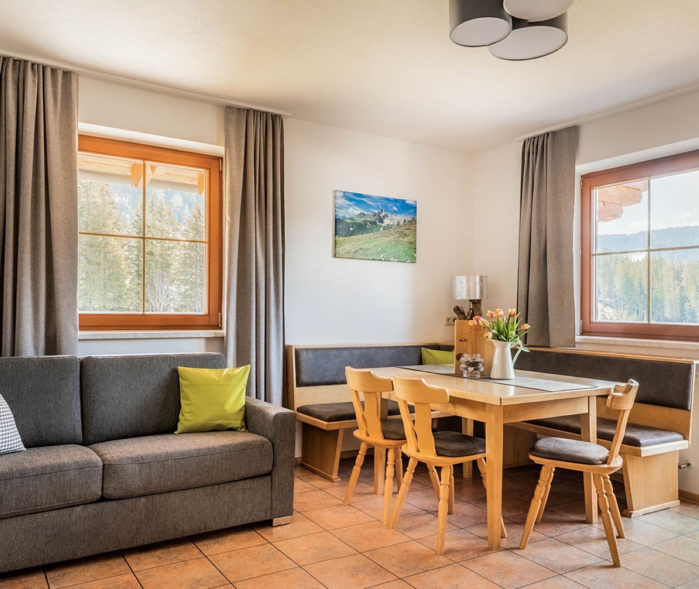 Appartment mit Esstisch, Sofa und einem Fenster mit Ausblick in die Natur © Bernd Suppan