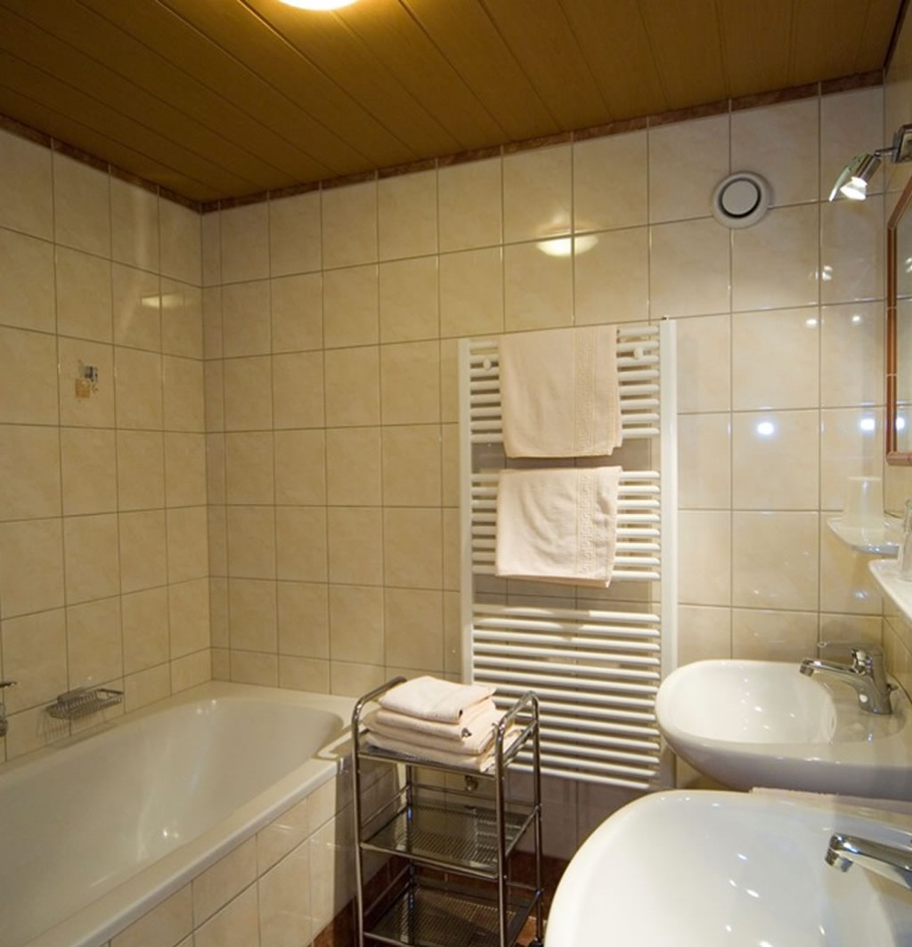 Badezimmer mit Doppelwaschbecken, Handtuchwärmer und Badewanne